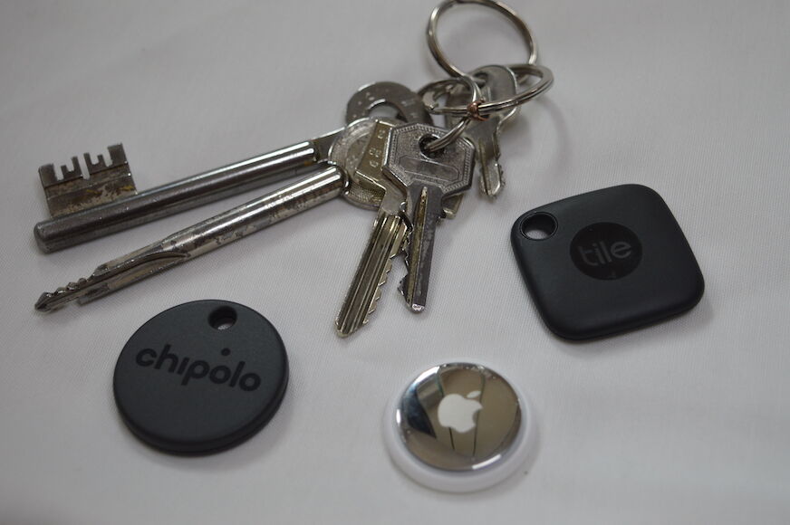 Apple AirTag, Chipolo ONE Spot und Tile Mate neben einem Schlüssel